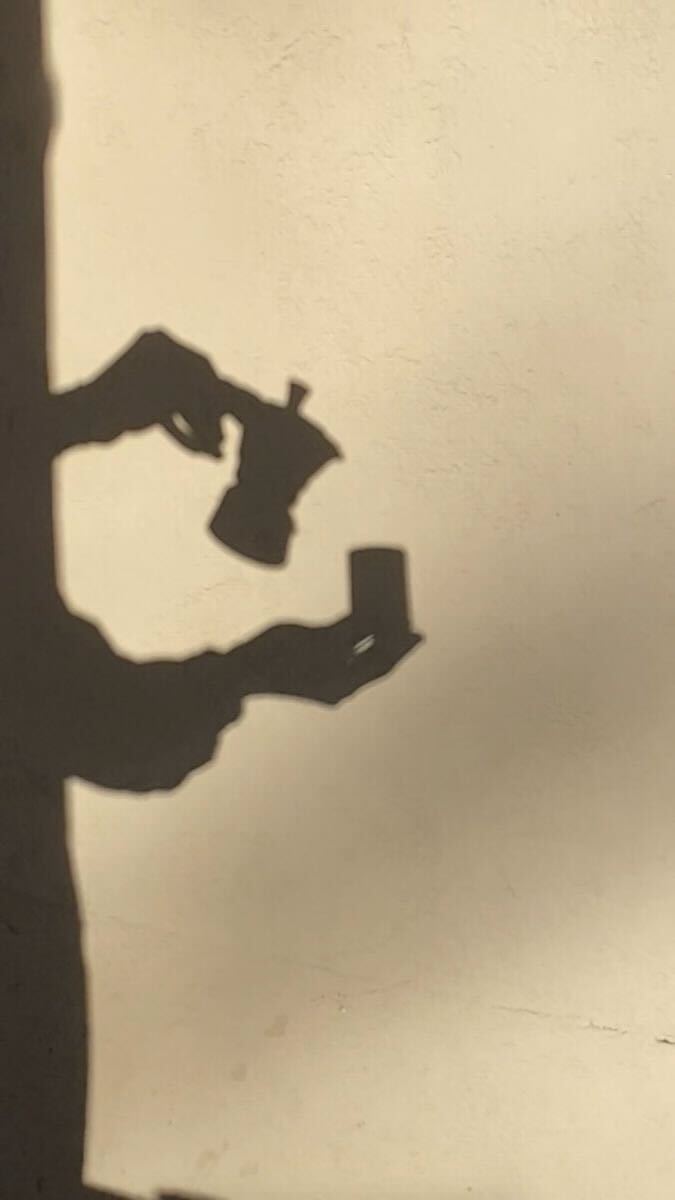 Ombre de mains tenant une tasse de café dans une lumière douce de fin d'après-midi